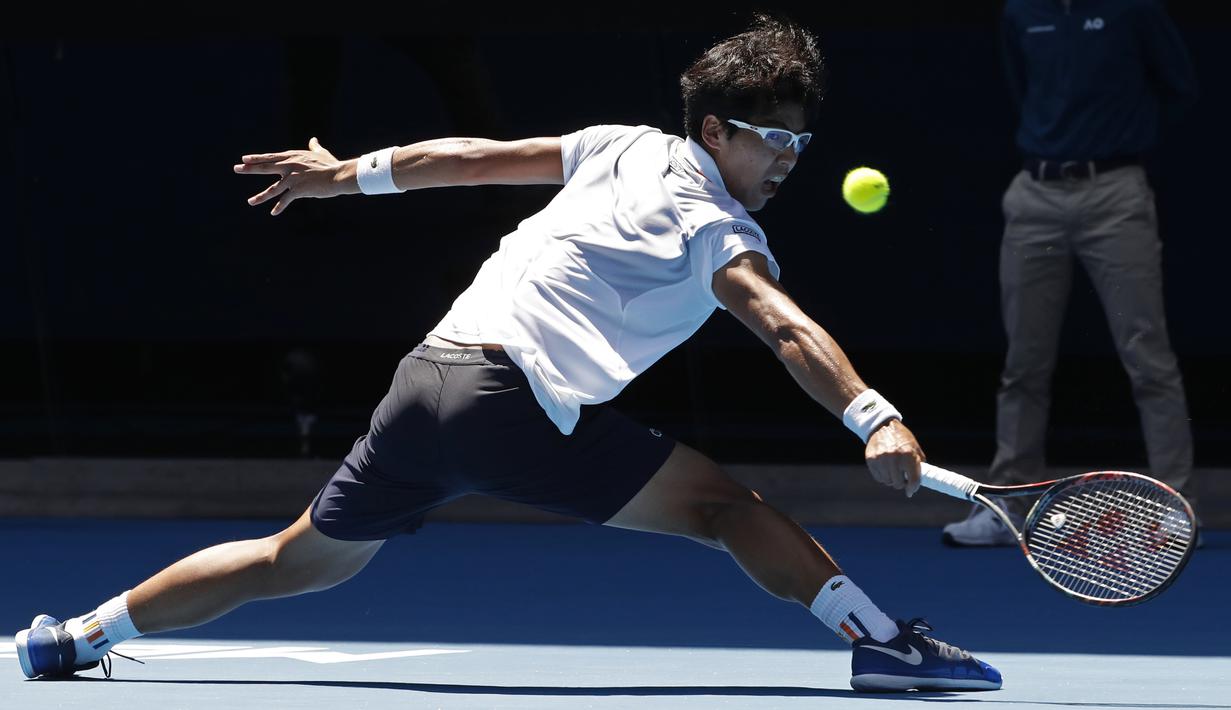 Gaya backhand petenis Korea Selatan, Chung Hyeon mengembalikan bola ke arah Tennys Sandgren pada perempat final Australia Terbuka 2018 di Melbourne, Australia, (24/1/2018). Chung menang 6-4, 7-6, 6-3. (AP/Ng Han Guan)