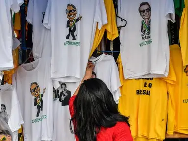 Kaus dengan gambar Calon Presiden Brasil, Jair Bolsonaro dari sayap kanan dijajakan di sebuah toko pinggir jalan yang populer di pusat kota Sao Paulo, 8 Oktober 2018. September lalu, Bolsonaro dirawat setelah ditusuk ketika kampanye. (AFP/NELSON ALMEIDA)