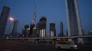 Sebuah taksi melintasi Jalan Sheikh Zayed 12 dekat Burj Khalifa, Dubai, Uni Emirat Arab, Minggu (5/4/2020). Pemerintah Dubai memberlakukan lockdown mulai 5 April 2020. (AP Photo/Jon Gambrell)