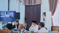 Bupati Meranti Muhammad Adil (pakai peci) yang dijerat KPK dengan 3 kasus korupsi saat menjalani sidang. (Liputan6.com/M Syukur)