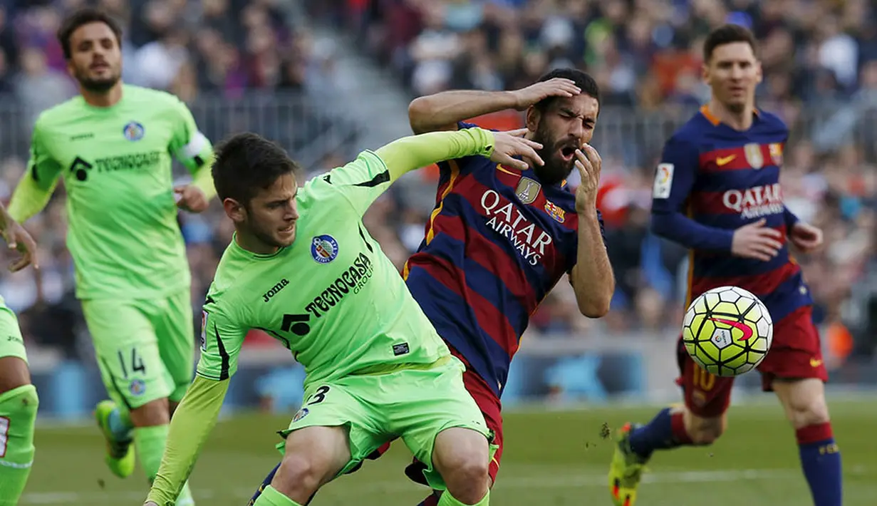 Gelandang Barcelona, Arda Turan, berebut  bola dengan gelandang Getafe, Alvaro Medran. Sementara bagi Getafe kekalahan ini membuat mereka terpuruk ke posisi 17, setinggat di atas zona degragasi. (Reuters/Albert Gea)
