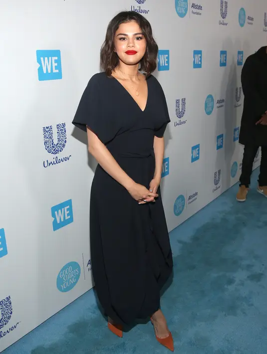 Penyanyi Selena Gomez berpose saat menghadiri WE Day California di The Forum di Inglewood, California (19/4). Selena Gomez tampil cantik dengan gaun berwarna biru tua dengan lipstik berwarna merah dibibirnya. (AP Photo/Jesse Grant)