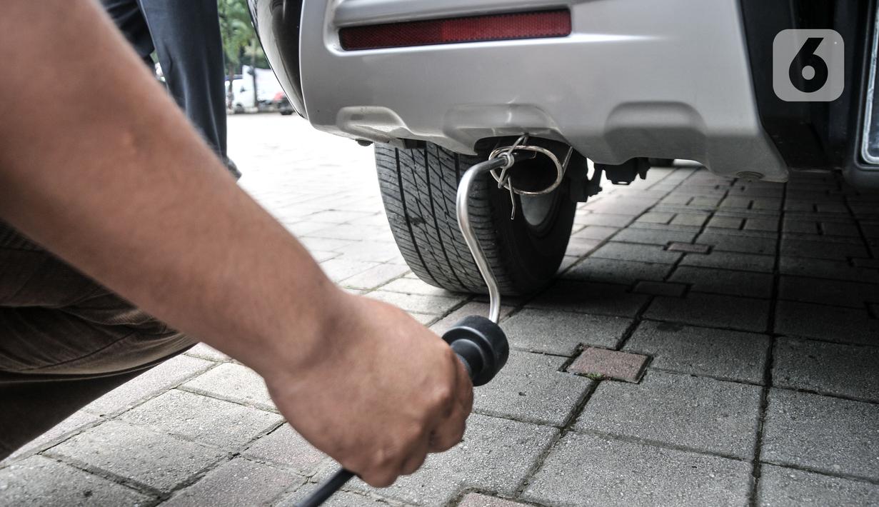 Petugas melakukan uji emisi mobil milik warga di IRTI Monas, Jakarta, Rabu (15/2/2023). Penerapan tarif disinsentif (tarif parkir tertinggi) berdasarkan Pergub Provinsi DKI Jakarta Nomor 66 Tahun 2020 Tentang Uji Emisi Gas Buang Kendaraan Bermotor. (merdeka.com/Iqbal S. Nugroho)
