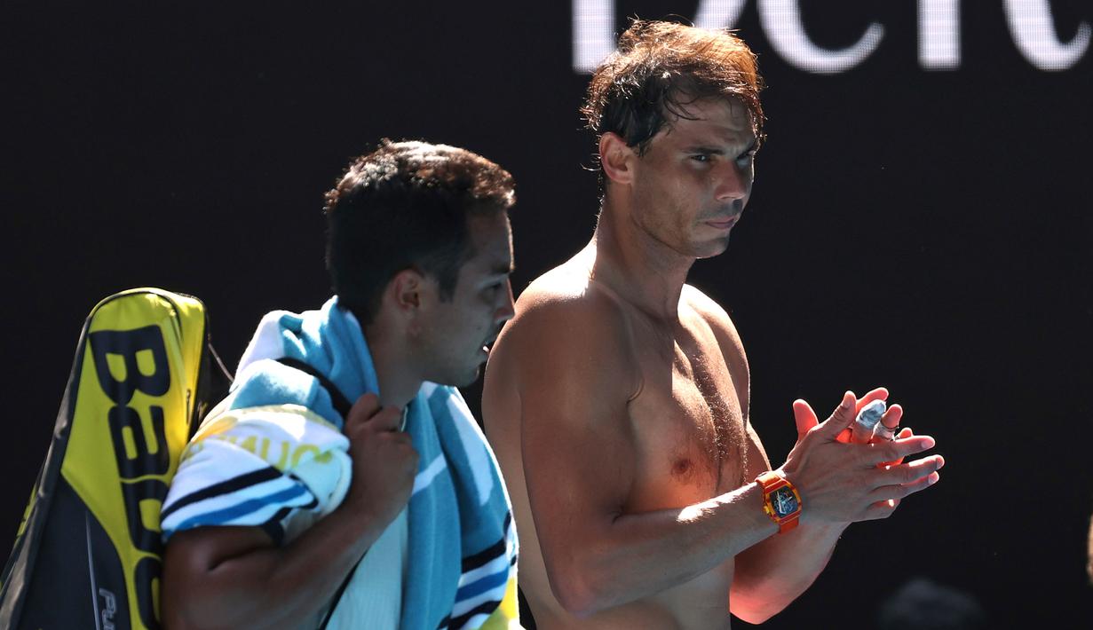 Petenis Rafael Nadal (kanan) dan Hugo Dellien meninggalkan Rod Laver Arena setelah pertandingan tunggal putra putaran pertama kejuaraan tenis Australia Terbuka di Melbourne, Australia, Selasa (21/1/2020). Nadal mengalahkan Dellien dan melaju ke putaran kedua Australia Terbuka. (AP Photo/Lee Jin-man)