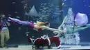 Penyelam mengenakan pakaian Sinterklas dan putri duyung saat beraksi di Coex Aquarium di Kota Seoul, Korea Selatan (4/12/2019). Natal menjadi salah satu hari libur nasional yang paling dinanti di Korea Selatan. (AP Photo/Ahn Young-joon)