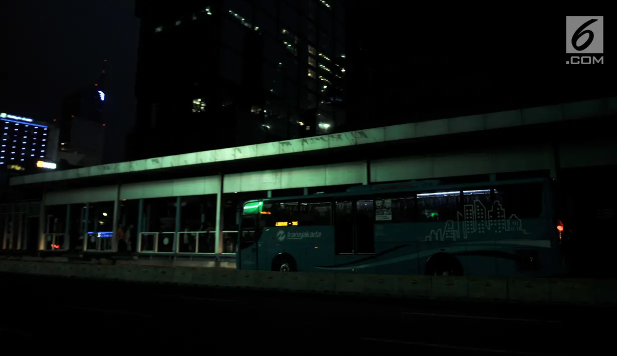 Bus Transjakarta berhenti untuk mengangkut penumpang saat listrik padam di Halte Tosari, Jakarta, Minggu (4/8/2019). Pemadaman listrik serentak yang terjadi sejak Minggu siang mengubah suasana malam di ibu kota menjadi gelap gulita. (merdeka.com/Iqbal S. Nugroho)