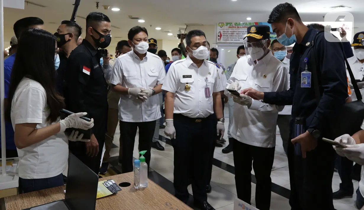 Menteri Perhubungan Budi Karya Sumadi (kedua kanan) bersama Wakil Gubernur DKI Jakarta Ahmad Riza Patria mengecek kesiapan sistem tiket elektronik atau Jakarta Electronic Ticketing Bus di Terminal Pulo Gebang, Jakarta Timur, Kamis (31/12/2020). (Liputan6.com/Helmi Fithriansyah)