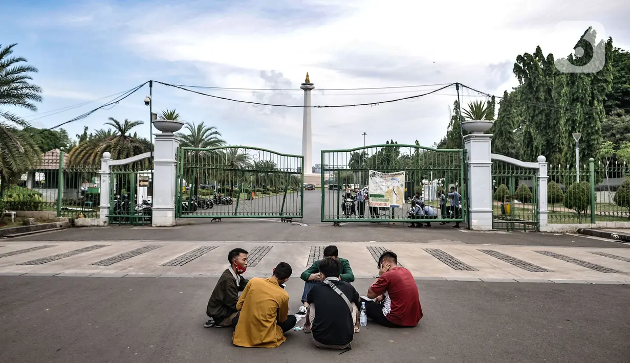Warga menikmati sore hari di depan gerbang masuk Monumen Nasional (Monas), Jakarta, Minggu (15/11/2020). Meski masih ditutup untuk umum sejak awal pandemi Covid-19, kawasan Monas tetap ramai dikunjungi warga untuk sekadar mengisi akhir pekan. (merdeka.com/Iqbal S Nugroho)