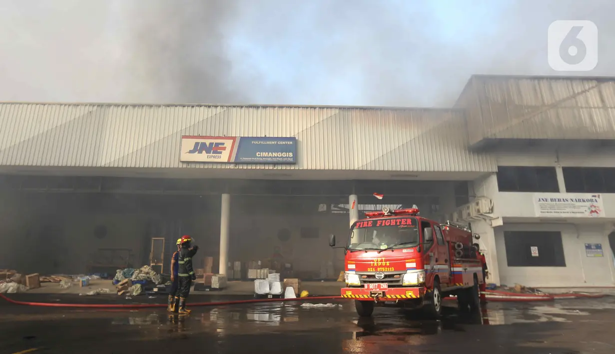 Petugas memadamkan api saat terjadi kebakaran di Gudang JNE Express, Jalan Pekapuran Raya, Depok, pada Senin (12/9/2022). Api pertama kali diketahui oleh salah satu sekuriti yang bertugas sekitar pukul 03.45 WIB. (Liputan6.com/Herman Zakharia)
