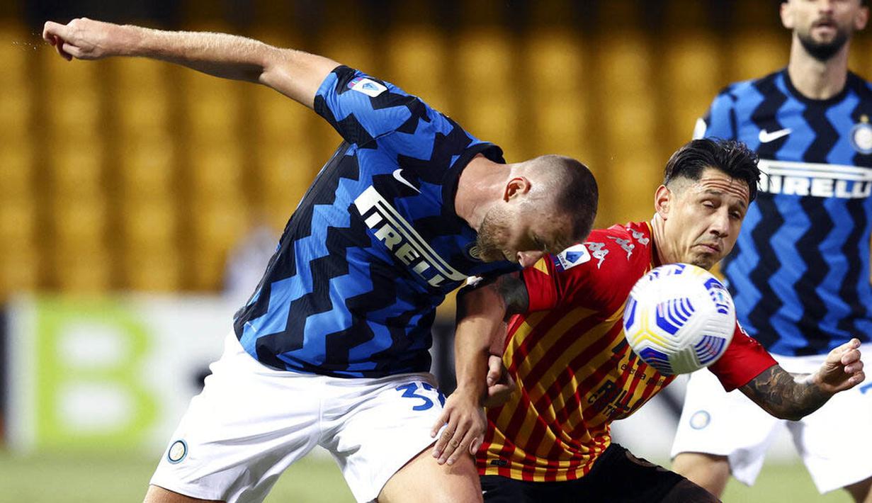 Bek Inter Milan, Milan Skriniar, berebut bola dengan pemain Benevento, Gianluca Lapadula, pada laga Liga Italia di Stadion Ciro Vigorito, Rabu (30/9/2020). Inter Milan menang dengan skor 5-2. (Alessandro Garofalo/LaPresse via AP)
