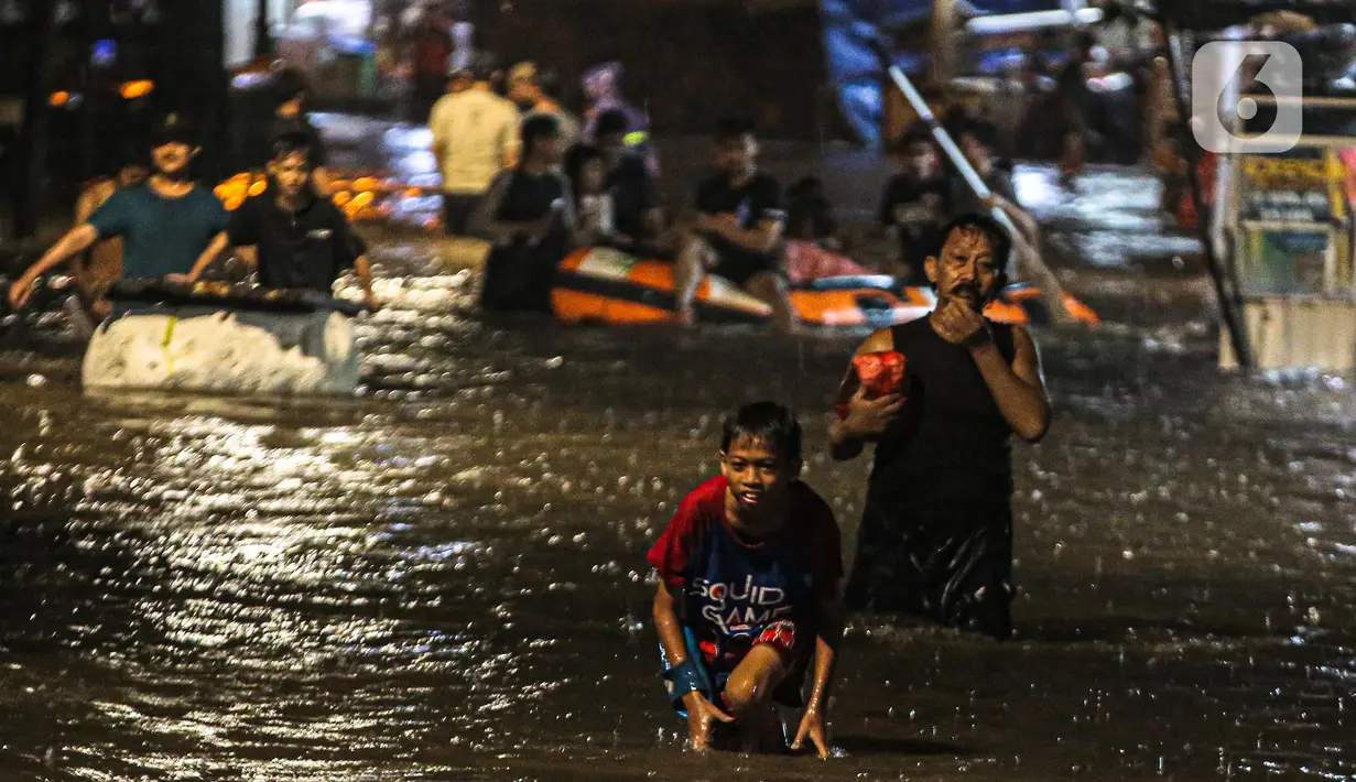 Sejumlah warga melintasi genangan banjir di kawasan Kemang, Jakarta, Selasa (4/10/2022). Jalan Kemang Utara IX tak bisa dilalui oleh kendaraan. Banjir menggenangi kawasan Pasar Kambing dan sejumlah rumah penduduk. (Liputan6.com/Faizal Fanani)