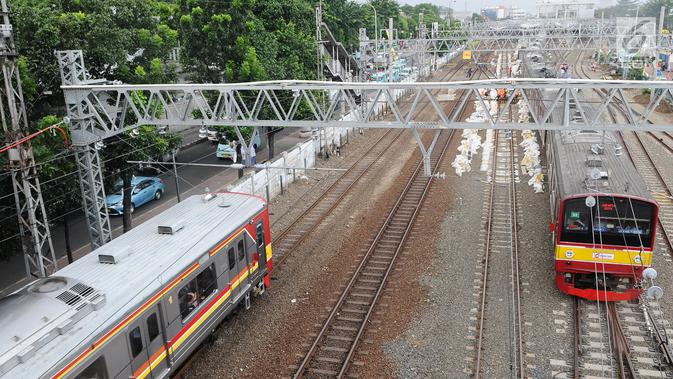 KRL melintas di jalur dwiganda atau double-double track (DDT) kawasan Jatinegara, Jakarta, Jumat (12/4). DDT segmen Jatinegara-Cakung mulai digunakan pada hari ini. (Liputan6.com/Herman Zakharia)