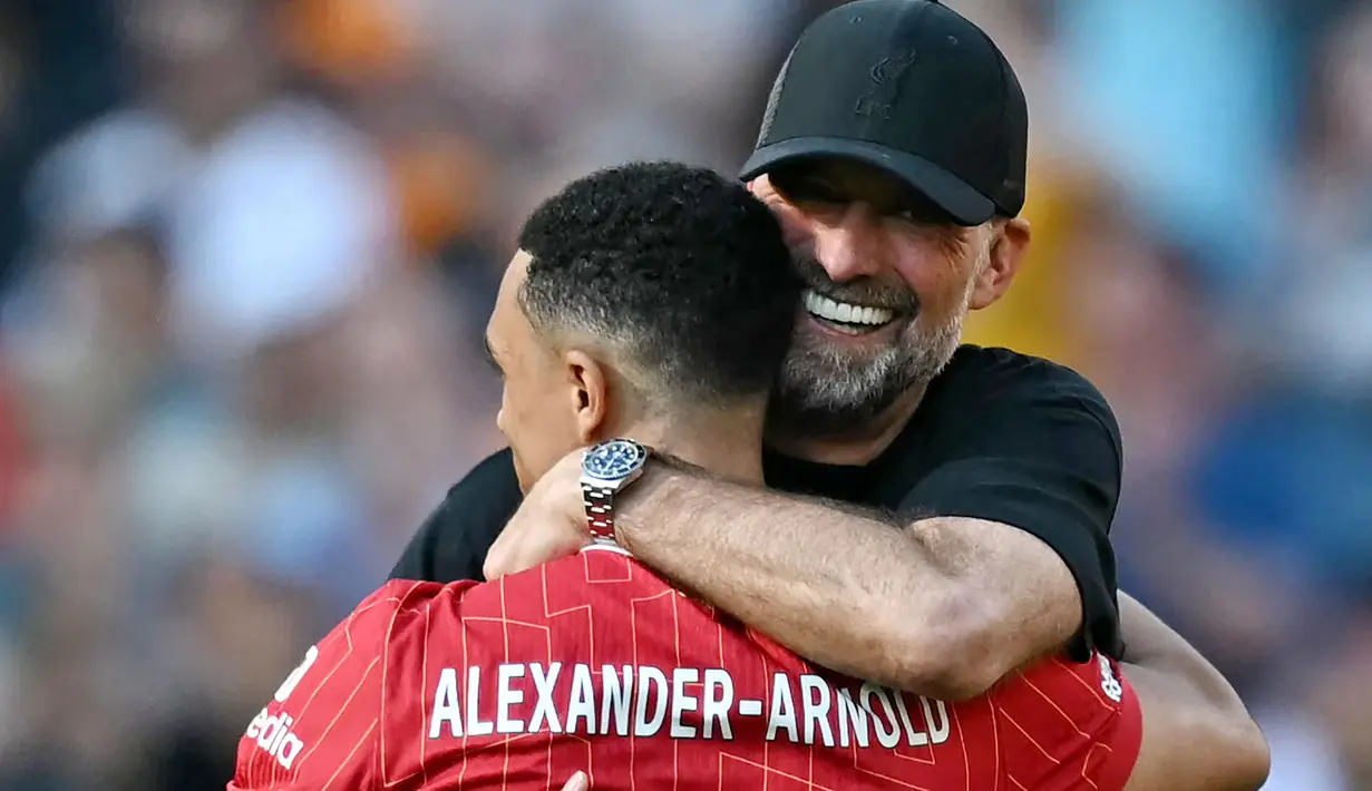 Pelatih Liverpool, Jurgen Klopp, berpelukan dengan Trent Alexander-Arnold saat seremoni perpisahan setelah laga melawan Wolverhampton Wanderers pada pekan terakhir Liga Inggris di Stadion Anfield, Minggu (19/05/2024). (AFP/Paul Ellis)