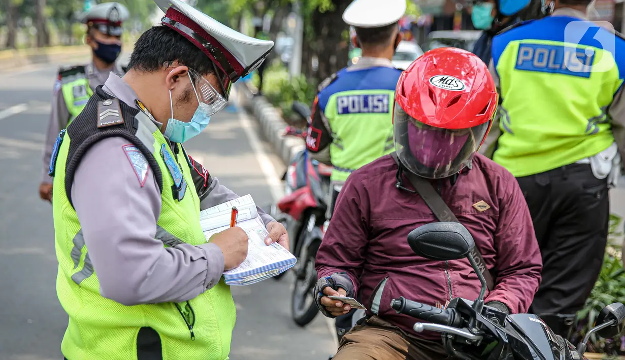 Polisi Lalu lintas menilang pengendara sepeda motor saat Operasi Patuh Jaya 2020 di Jalan Letjen Suprapto, Jakarta Pusat, Kamis (23/7/2020). Ditlantas Polda Metro Jaya menggelar Operasi Patuh Jaya 2020 hingga 5 Agustus untuk menertibkan masyarakat dalam berlalu lintas. (Liputan6.com/Faizal Fanani)