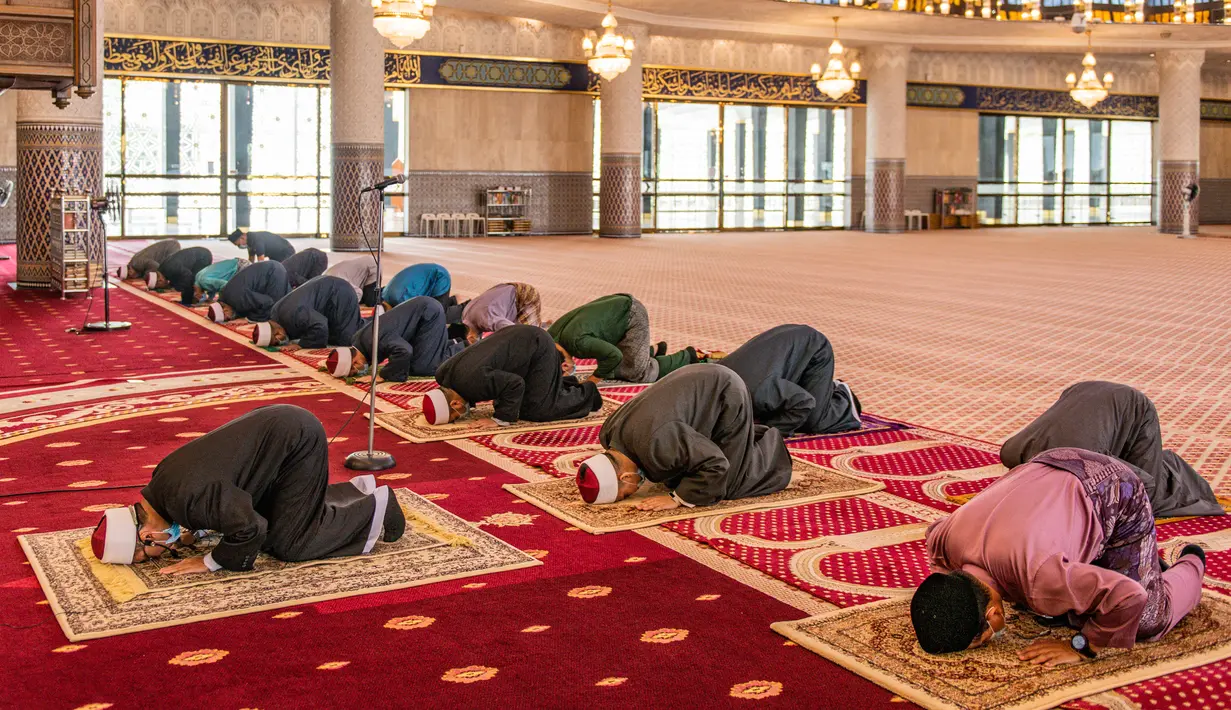 Petugas masjid melaksanakan salat Jumat dengan menerapkan jaga jarak aman saat Ramadan di Masjid Negara Malaysia, Kuala Lumpur, Malaysia, Jumat (15/5/2020). Pemerintah Malaysia mengizinkan salat berjemaah di masjid setelah sebelumnya dilarang karena pandemi virus corona COVID-19. (Mohd RASFAN/AFP)