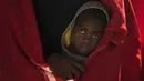 Seorang anak imigran berdiri di kapal penyelamat ketika tiba di pelabuhan Malaga, Spanyol, Selasa, (11/2/2020). Otoritas maritim Spanyol pada Senin (11/2) menyelamatkan 119 imigran dari laut dan sedang mencari 67 lainnya yang mencoba mencapai pantai Eropa. (AP Photo/Jesus Merida)
