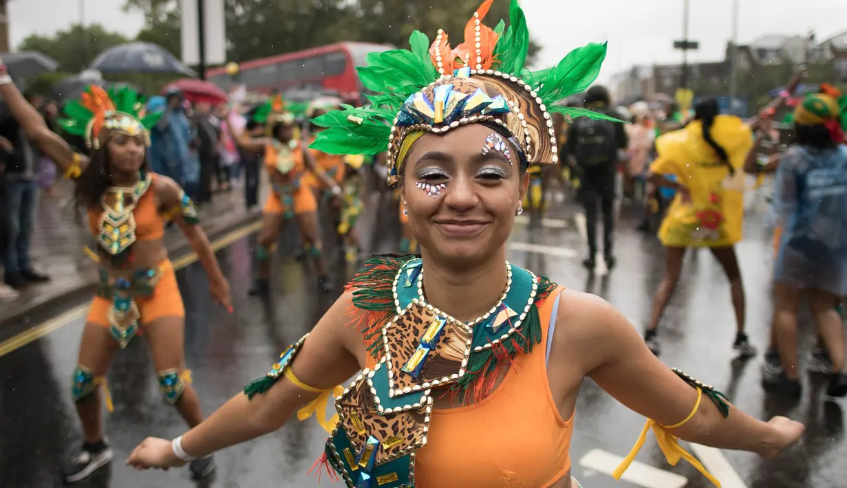 Seorang penari ambil bagian pada parade hari pertama Karnaval Notting Hill di London barat, Minggu (26/8). Para peserta mengenakan kostum tradisional Karibia dan modern yang artistik . (Stefan Rousseau/PA via AP)
