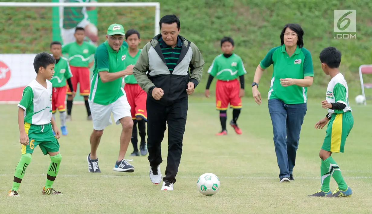 Menpora, Imam Nahrawi didampingi Dharnesh Gordhon dan Prawitya Soemadijo menggiring bola pada acara kompetisi sepak bola U-12 antar Sekolah Dasar, MILO Football Championship 2018, di Senayan, Jakarta, Sabtu (24/3).  (Liputan6.com/Pool/Rizky)