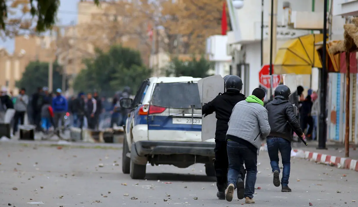 Pengunjuk rasa terlibat bentrok dengan aparat kepolisian di luar kantor pemerintah setempat di Kasserine, Tunisia, Kamis (21/1). Para pengangguran muda turun ke jalan memprotes keterpurukan ekonomi dan sulitnya lapangan kerja. (REUTERS/Amine Ben Aziza)