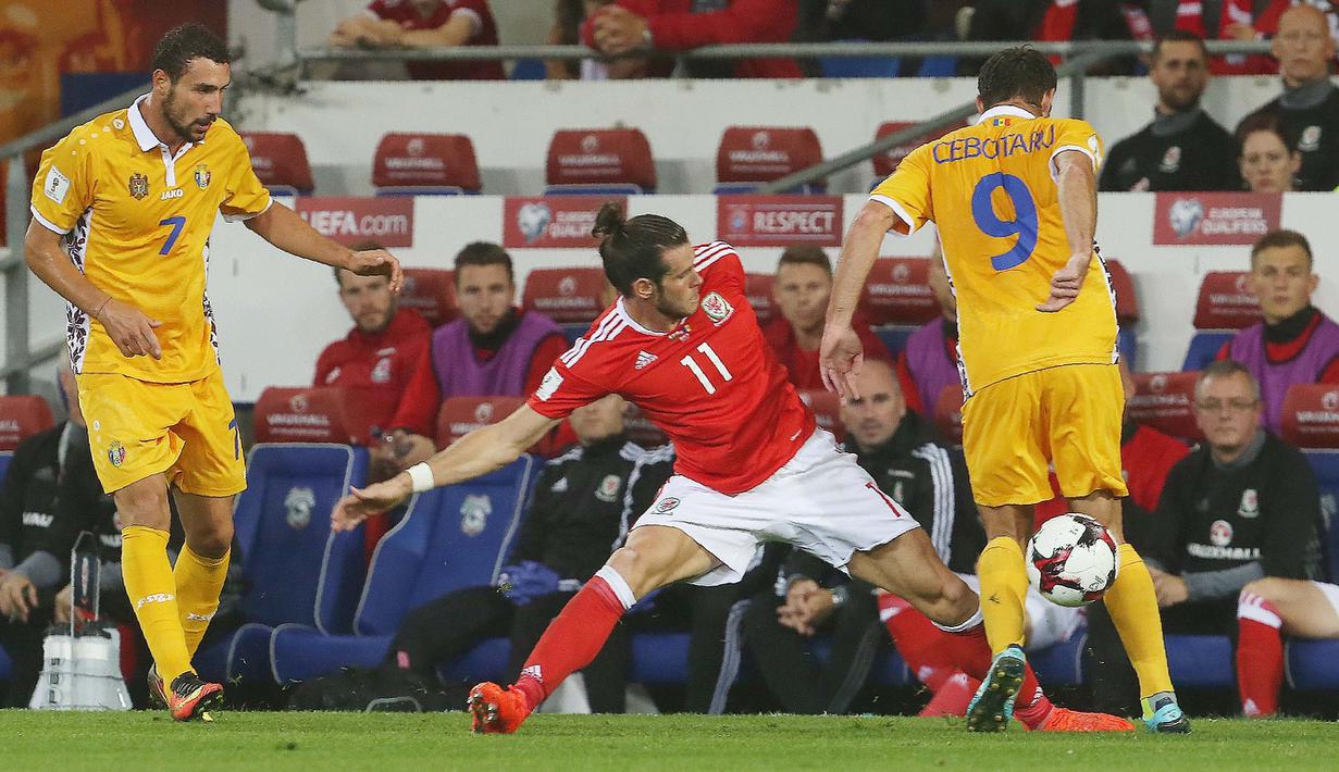 Gareth Bale mencoba melewati hadangan pemain Moldova, Eugen Cebotaru pada kualifikasi Piala Dunia 2018 di Stadion Cardiff City Stadium, Cardif, Wales Selatan, (6/9/2016) dini hari WIB. (AFP/Geoff Caddick)