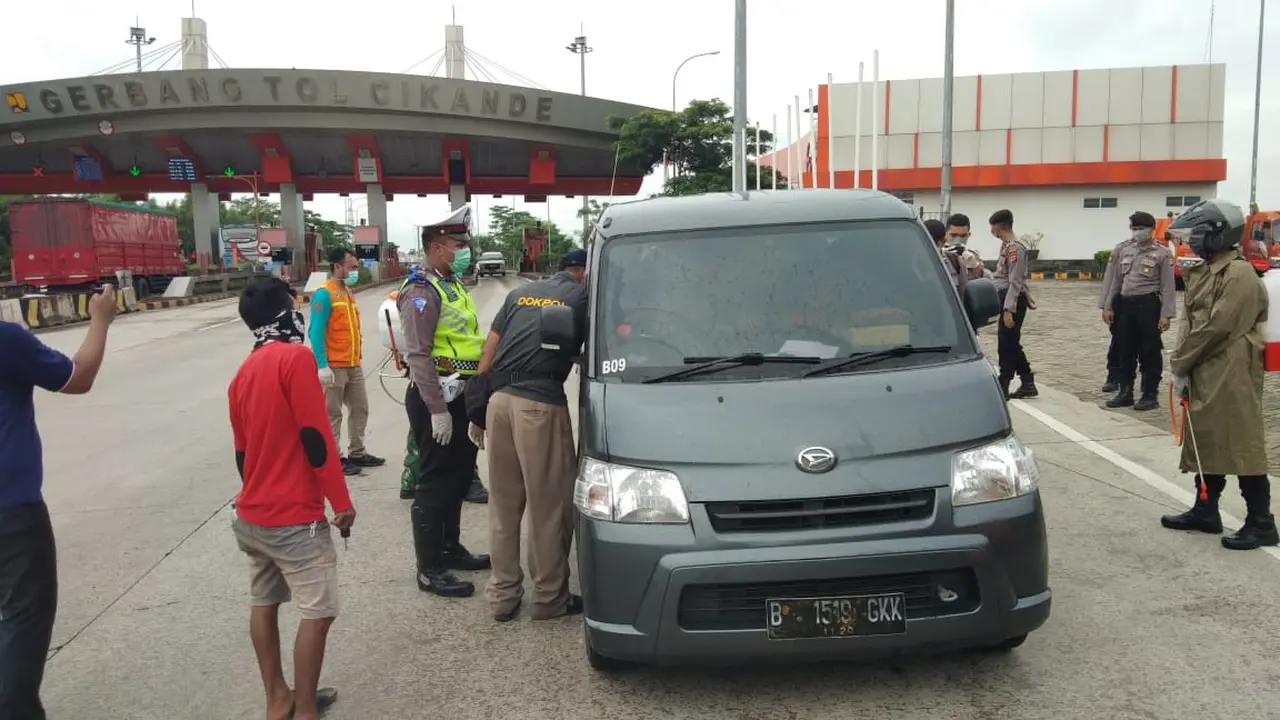 Polisi menyemprot mobil yang masuk wilayah Serang, Banten dengan cairan disinfektan