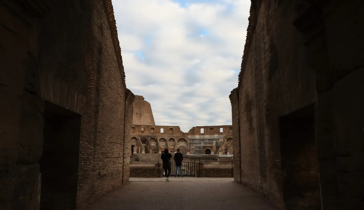 Para pengunjung berfoto di Colosseum di Roma, Italia (4/11/2020). Museum, galeri, teater, balai konser, bioskop, dan tempat perjudian harus ditutup, sementara pertemuan publik, perayaan, pameran, festival, dan berbagai acara, baik outdoor maupun indoor, dilarang. (Xinhua/Cheng Tingting)
