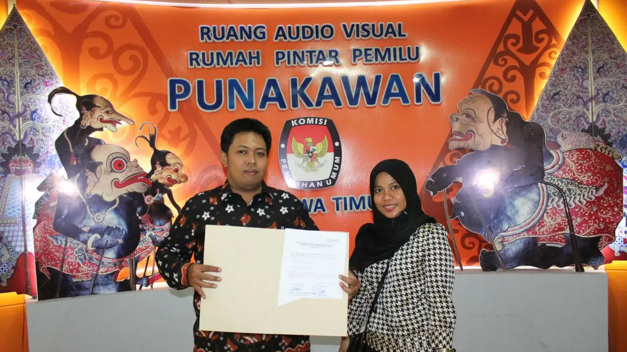 Liaison Officer (LO) Hadi Mulyo Utomo (kiri) dan Eni Rachmayanti menunjukkan tanda terima dokumen perbaikan pasangan calon Khofifah-Emil dari KPU Jatim. (Liputan6.com/Dian Kurniawan).