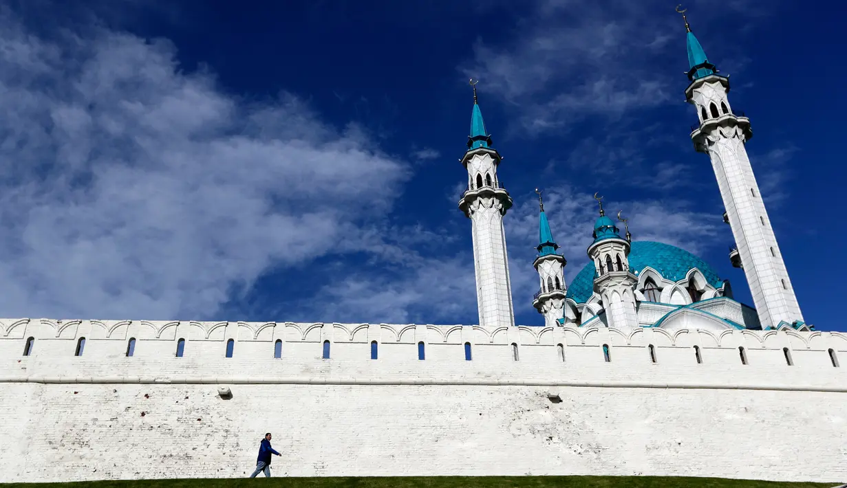 Seorang pria melintas di depan masjid Kul Sharif yang terletak di Kazan, Rusia. Masjid ini tak hanya dikunjungi warga yang ingin beribadah, tapi juga turis-turis dari berbagai daerah lain. (AP Photo/Thanassis Stavrakis)