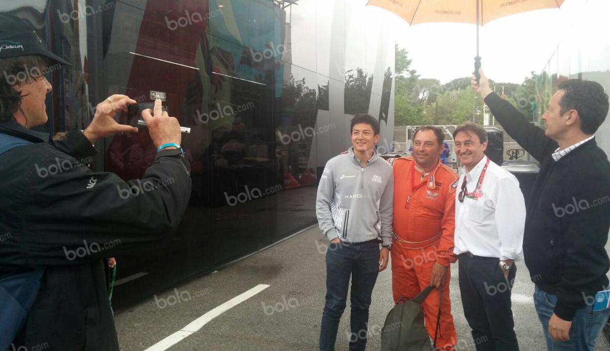 Pebalap Manor Racing asal Indonesia, Rio Haryanto, berfoto bersama seorang panitia lomba dan Adrian Campos (baju putih) seusai latihan bebas kedua F1 GP Spanyol di Sirkuit Catalunya, Spanyol, Jumat (13/5/2016). (Bola.com/Reza Khomaini)