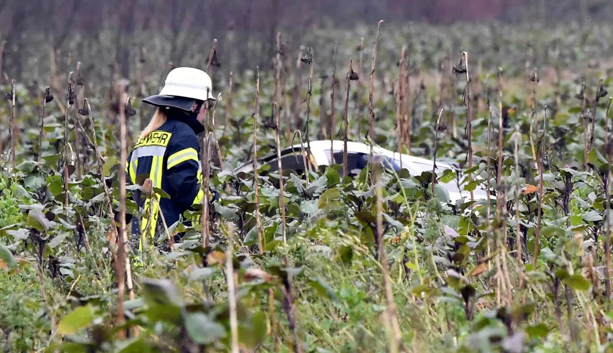 Petugas pemadam kebakaran memeriksa lokasi terjadinya kecelakaan udara antara pesawat kecil dengan helikopter di kota Philippsburg, Jerman, Selasa (23/1). Penyebab insiden belum diketahui seiring penyelidikan yang masih dilakukan. (Rene Priebe/dpa via AP)