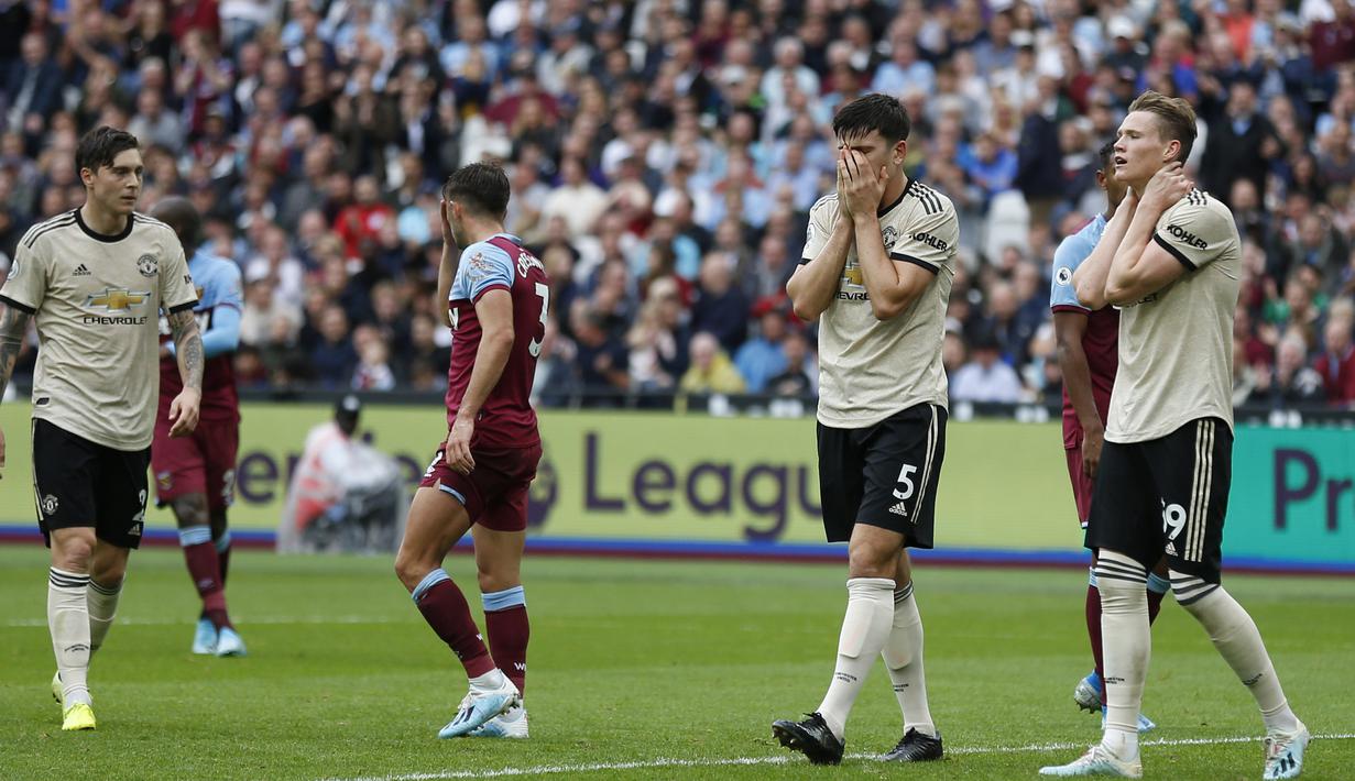 Para pemain Manchester United tampak kecewa usai dikalahkan West Ham pada laga Premier League di Stadion London, London, Minggu (22/9). West Ham menang 2-0 atas MU. (AFP/Ian Kington)