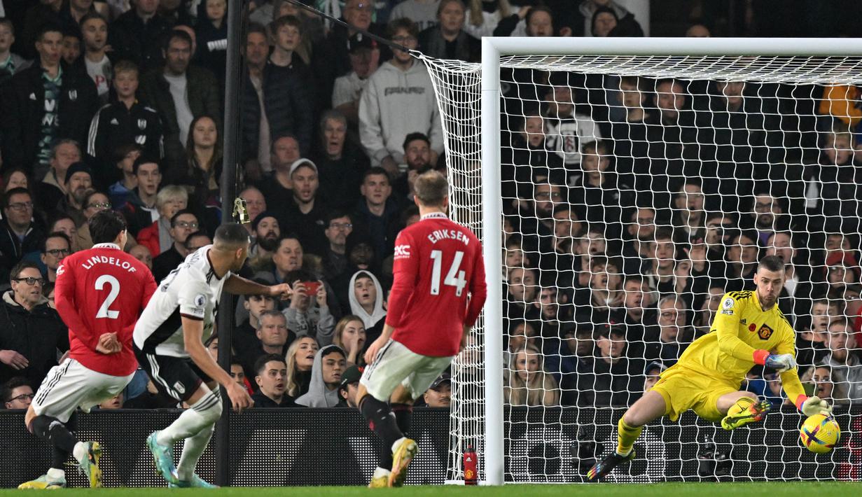 <p>Penjaga gawang Manchester United, David de Gea (kanan), berhasil menggagalkan tendangan dari pemain Fulham, Carlos Vinicius (dua kiri), dalam pertandingan pertandingan lanjutan Liga Inggris 2022/2023 yang berlangsung di Craven Cottage, Minggu (13/11/2022). (AFP/Glyn Kirk)</p>