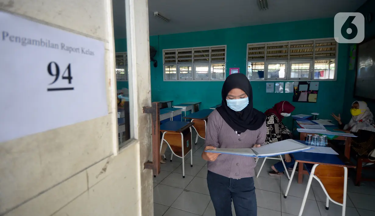 Wali murid usai mengambil raport secara bergilir di SMP Negeri 18 Tangerang Selatan, Banten, Kamis (17/12/2020). Untuk dapat mengambil raport  orangtua siswa wajib mengenakan masker. (merdeka.com/Dwi Narwoko)