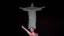 <p>Seorang penggemar berpose di depan gambar Kristus Sang Penebus untuk menyambut penyanyi AS Taylor Swift di Rio de Janeiro, Brasil, pada 16 November 2023. (Florian Plaucher / AFP)</p>