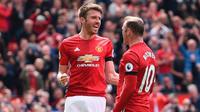 Wayne Rooney (kanan) bersama Michael Carrick merayakan gol Manchester United ke gawang Swansea City pada laga Premier League di Old Trafford, Manchester, Minggu (30/4/2017). (AFP/Oli Scarff)