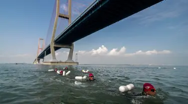 Prajurit Korps Marinir TNI AL berenang melintas selat Madura dari Surabaya sepanjang 5,4 km, Kamis (28/4). Renang yang mengambil start di Jembatan Suramadu dan finish di Bangkalan Madura ini untuk memperingati HUT Pasmar 1 ke-15. (Juni KRISWANTO/AFP)