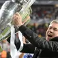 Carlo Ancelotti tersenyum lebar pamerkan trofi Liga Champions (MIGUEL RIOPA / AFP)