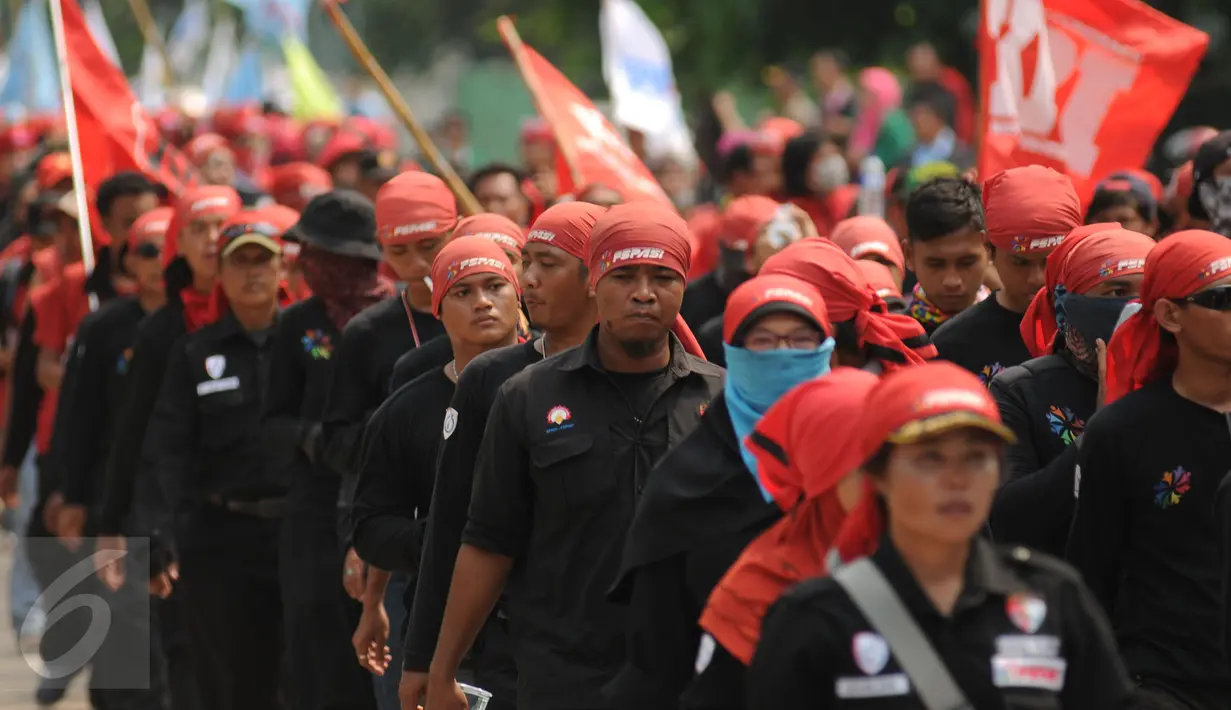 Ratusan buruh saat melintasi jalan di Kawasan Industri Pulogadung menuju Tugu Proklamasi, Jakarta, Jumat (20/11/2015). Aksi ini bagian dari jalan kaki Bandung-Jakarta menolak PP 78 th 2015 tentang pengupahan. (Liputan6.com/Helmi Fithriansyah)