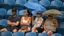 Penonton menggunakan payung untuk berlindung dari hujan saat penangguhan pertandingan perempat final tunggal putri antara petenis Kazakhstan Elena Rybakina dan petenis Latvia Jelena Ostapenko pada hari kesembilan turnamen tenis Australia Open di Melbourne pada 24 Januari 2023.
(ANTHONY WALLACE / AFP)