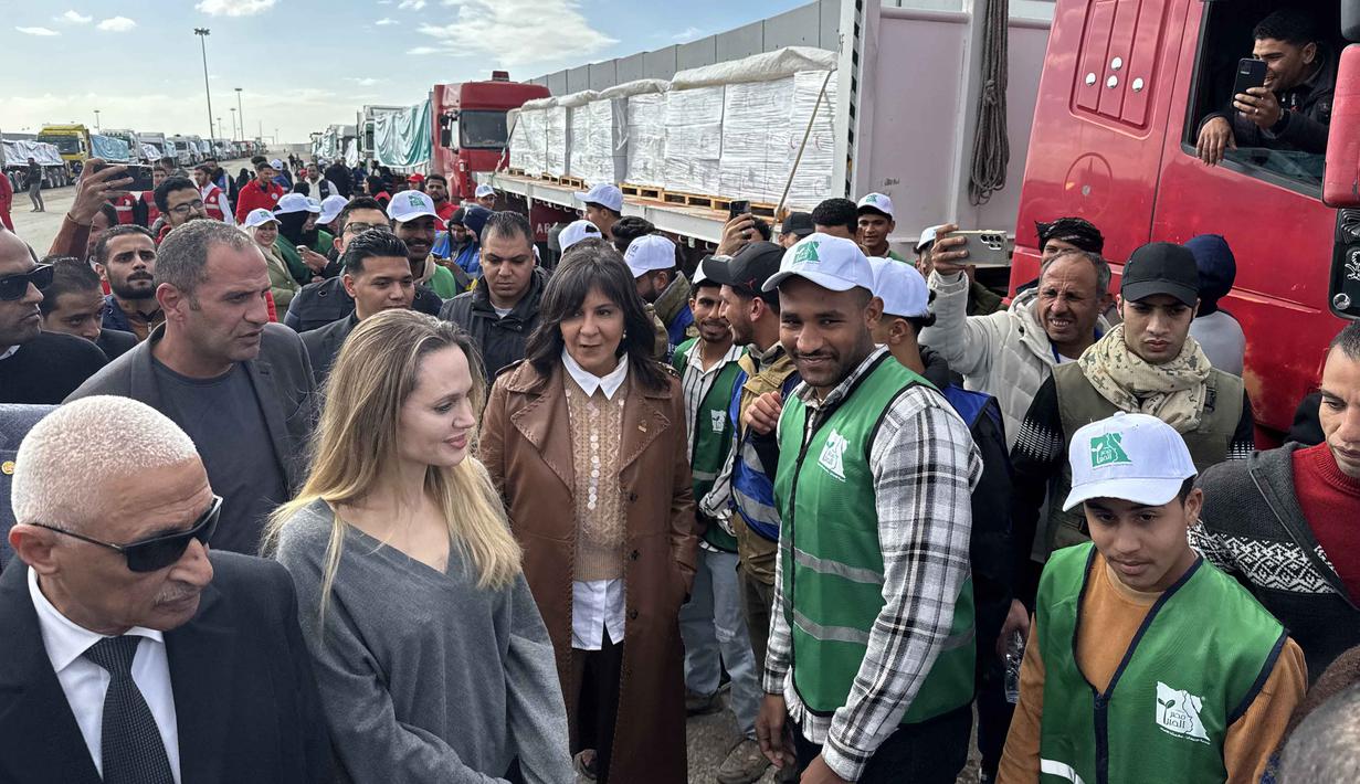 Kantor Media Pemerintah di Gaza (GMO) yang dikelola Hamas mengatakan hujan deras dan angin kencang telah menghancurkan tenda-tenda darurat dan reruntuhan bangunan yang digunakan para pengungsi untuk bertahan hidup. Tampak dalam foto, aktris Amerika Serikat (AS), Angelina Jolie berbicara dengan para karyawan lembaga bantuan di perbatasan Rafah Mesir, pada Jumat 2 Januari 2026. (Foto oleh AFP)