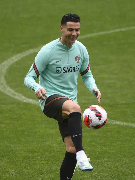 Penyerang Portugal, Cristiano Ronaldo mengontrol bola saat mengikuti sesi latihan di stadion Dragao di Porto (28/3/2022). Portugal akan menghadapi Makedonia Utara di final Play-off Jalur C Kualifikasi Piala Dunia 2022 zona Eropa. (AFP/Miguel Riopa)