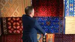 Pemilik The Afghan Rug Shop James Wilthew mengatur pajangan di tokonya di Hebden Bridge, Inggris, 20 Agustus 2021. Bisnis yang menjual karpet tenunan tangan warna-warni dan kaca buatan tangan dari Afghanistan ini takut akan pemasok mereka setelah Taliban menguasai Afghanistan. (LINDSEY PARNABY/AFP)
