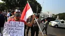 Seorang mahasiswa Riau Jabodetabek membawa bendera merah putih saat unjuk rasa di depan Istana Merdeka, Jakarta, Jumat (18/9/2015). Mereka menuntut penegakan hukum hingga tuntas pelaku pembakaran. (Liputan6.com/Faizal Fanani)