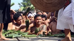 Sejumlah pria Bali menonton Perang Pandan di Bali (8/6). Perang Pandan merupakan salah satu tradisi yang dilakukan untuk menghormati dewa Indra atau Dewa perang. (AP/Firdia Lisnawati)