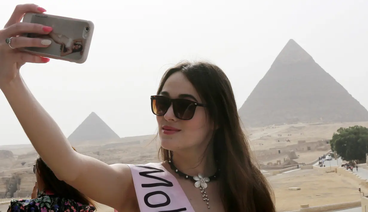 Cantiknya Kontestan Miss ECO Universe saat berselfie dengan latar belakang segitiga piramida di pinggiran Kairo, Mesir (10/4). Pemenang Miss Eco Universe 2016 akan memenangkan hadiah uang tunai USD 10.000. (REUTERS/Mohamed Abd El Ghany)
