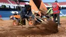 Seorang suporter menaburkan pasir saat menyelesaikan pembangunan stadion baru di Asuncion, Paraguay (22/6). Pembangunan stadion memiliki nilai proyek USD 15 juta atau Rp 199 miliar tersebut. (AFP Photo/Norberto Duarte)