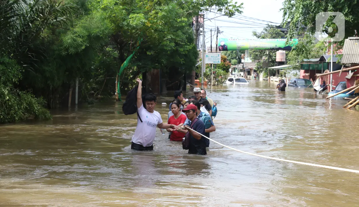 Warga berusaha melintasi banjir yang merendam perumahan Ciledug Indah, Tangerang, Banten, Kamis (2/1/2020). Memasuki hari kedua, kondisi perumahan tersebut masih tergenang banjir setinggi dada orang dewasa. (Liputan6.com/Angga Yuniar)