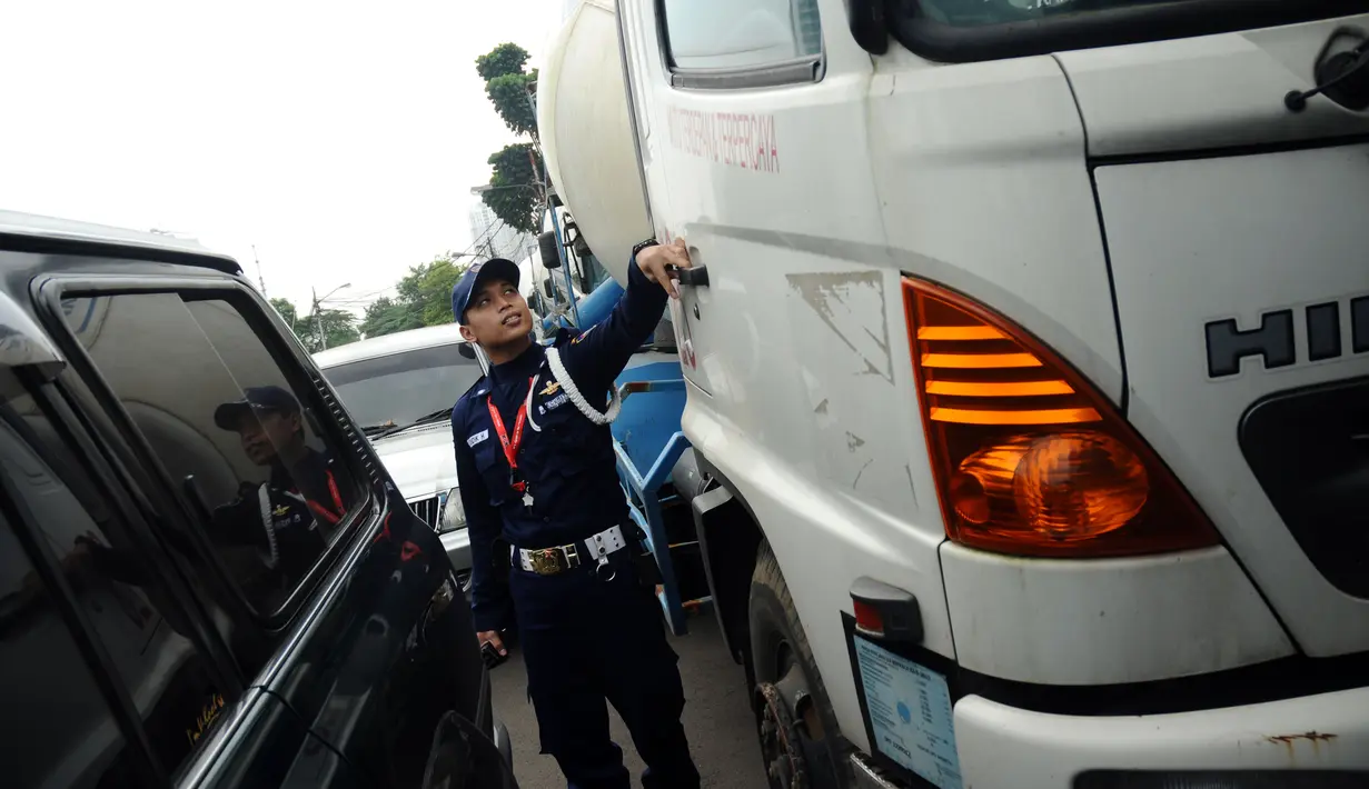 Salah satu petugas keamanan gedung KPK melakukan pengecekan pada delapan truk pengaduk semen milik TB Chaeri Wardhana yang kini disita KPK. (Liputan6.com/Helmi Fithriansyah)