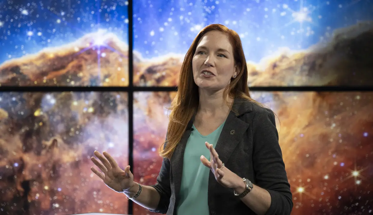 Dalam gambar yang dirilis oleh NASA ini, Deputi Ilmuwan Proyek Teleskop Luar Angkasa James Webb NASA untuk Komunikasi Amber Straughn berbicara tentang gambar inframerah dari wilayah pembentuk bintang yang disebut NGC 3324 di Nebula Carina seperti yang ditampilkan pada layar saat siaran yang merilis teleskop gambar penuh warna pertama dari Teleskop Webb di Pusat Penerbangan Luar Angkasa Goddard NASA, Greenbelt, Maryland, Amerika Serikat, 12 Juli 2022. (Bill Ingalls/NASA via AP)