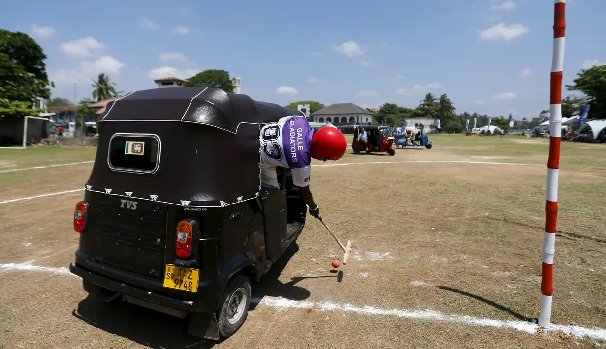 Peserta memukul bola saat tampil di kompetisi "Tuk Tuk Polo" di Galle, Sri Lanka, (21/2). Tuk Tuk merupakan kendaraan roda tiga atau bisasa dikenal Bajaj yang menjadi alat transportasi warga Sri Lanka. (REUTERS/Dinuka Liyanawatte)